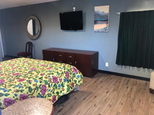 a bedroom with a bed and a tv on the wall at King Castle Motel in Los Angeles