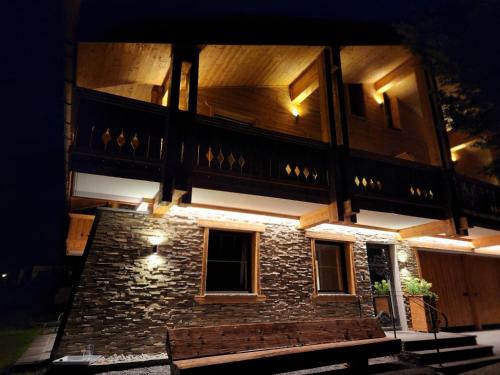 a building with lights on the side of it at night at Apartment Marent Garten Chalet in Vandans