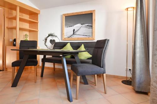 a dining room with a black table and chairs at Apartment Marent Garten Chalet in Vandans