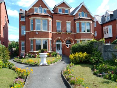 una gran casa de ladrillo con un jardín delante de ella en St Annes Lodge Apartments, Lytham St Annes, en Lytham St Annes