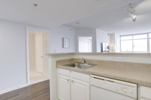 a kitchen with white cabinets and a sink at Wonderful 1 Bedroom Condo At Ballston With Gym in Arlington