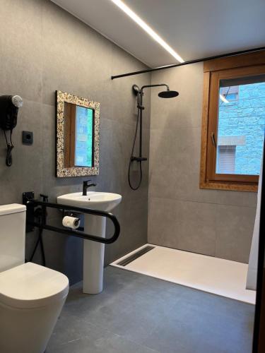 a bathroom with a toilet and a sink and a shower at Hotel Els Encantats in Espot
