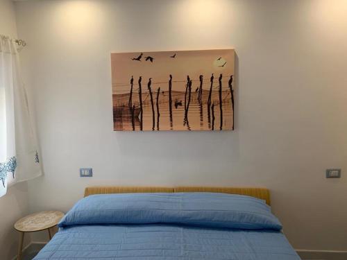 1 dormitorio con 1 cama con una pintura en la pared en NERONE HOUSE, en Diamante