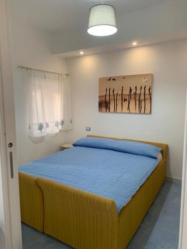 a bedroom with a bed with a painting on the wall at NERONE HOUSE in Diamante