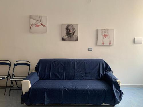 a blue couch in a room with pictures on the wall at NERONE HOUSE in Diamante