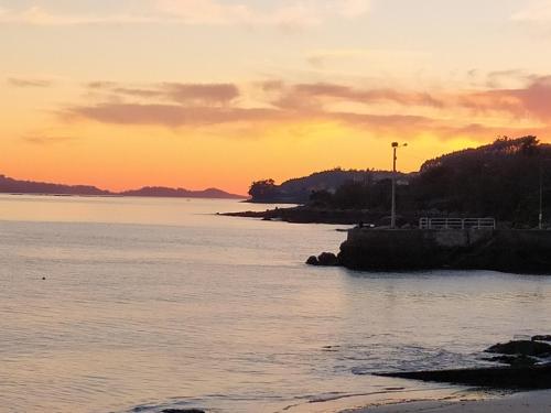 a sunset over a body of water with the sun setting at HOTEL MAREA in Poio