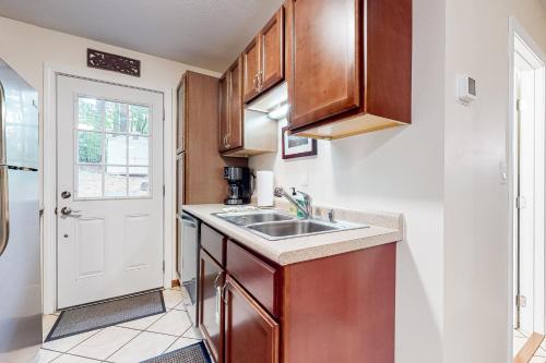 a kitchen with wooden cabinets and a sink at Gunstock Getaway in Gilford