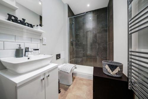 a white bathroom with a sink and a shower at Marble DELUXE - City Centre Apt- Parking & Wifi in Maidstone