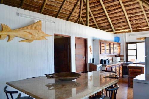 Mozambique,Inhambane,Barra -Entire Beach House في إنهامبان: مطبخ مع طاولة مع سمك على الحائط