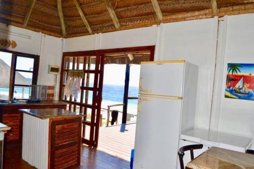 a kitchen with a refrigerator and a view of the ocean at Mozambique,Inhambane,Barra -Entire Beach House in Inhambane