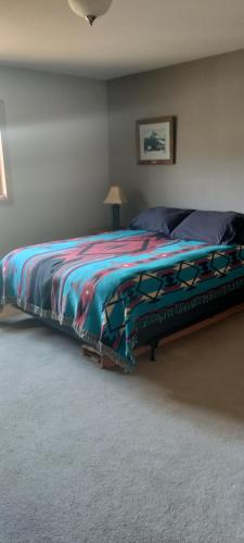 sypialnia z łóżkiem z kolorowym kocem w obiekcie Rena's Bed and Breakfast w mieście Richards Trailer Court