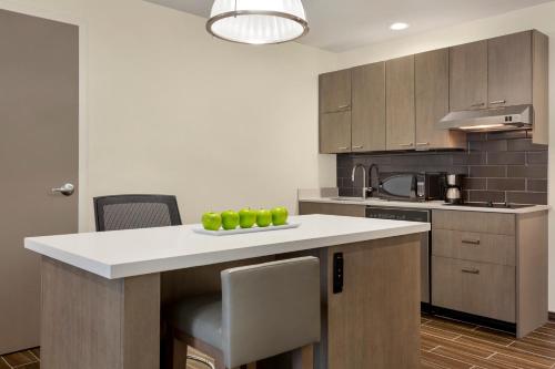 a kitchen with a counter with green apples on it at Hyatt House Bryan/College Station in College Station