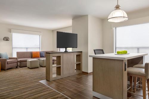 a living room with a flat screen tv on a counter at Hyatt House Bryan/College Station in College Station