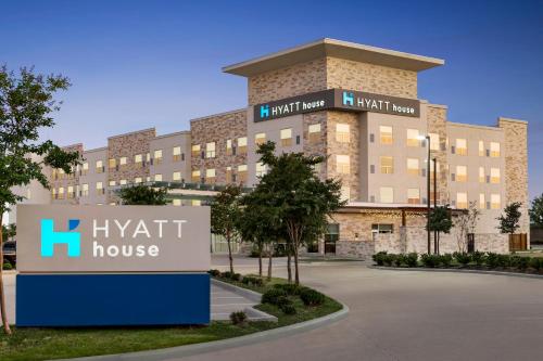 a large building with a sign in front of it at Hyatt House Bryan/College Station in College Station