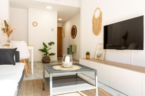 een woonkamer met een tv en een tafel bij La Besana Home in Málaga