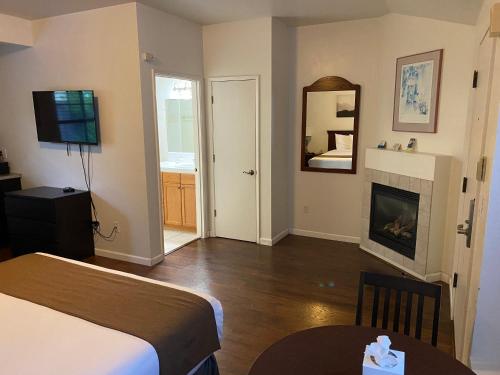 a hotel room with a bed and a fireplace at Bide-A-Wee Inn and Cottages in Pacific Grove