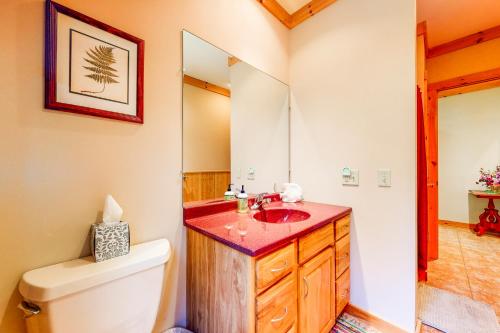 a bathroom with a sink and a toilet and a mirror at White Mountain Log Home in Carroll