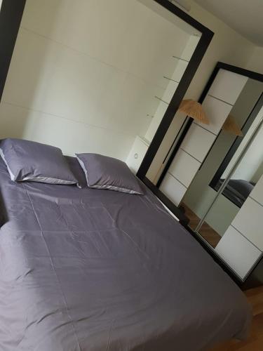 un grand lit dans une chambre avec une fenêtre dans l'établissement PARIS AURIOL, à Paris