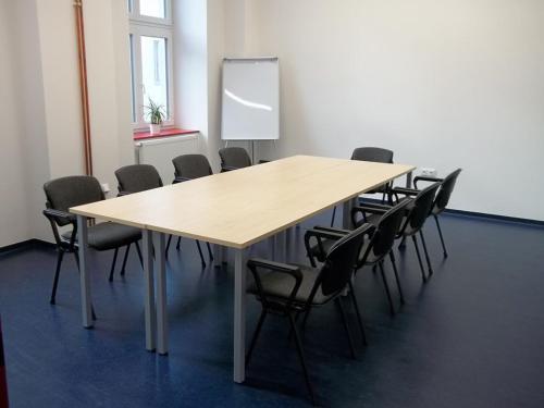a conference room with a wooden table and chairs at EA Business Hotel Jihlava in Jihlava