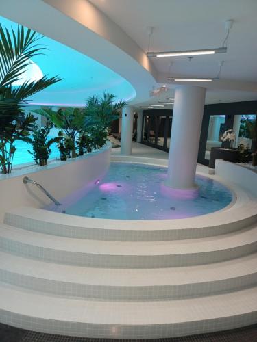een hot tub in de lobby van het hotel met een trap bij Hanza Tower AJP Lux Apartment in Szczecin