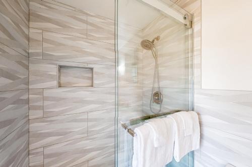 y baño con cabina de ducha y toallas blancas. en Peaceful Pintail, en Ocean Pines