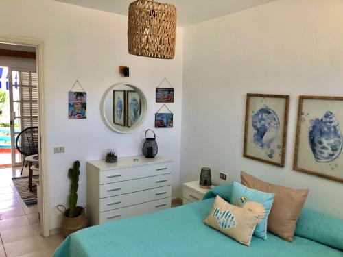a bedroom with a blue bed and a dresser at Casa La Galera (Playa a 50 metros) in Corralejo