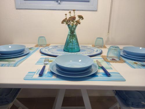 een tafel met borden en een vaas met bloemen erin bij Luxury loving home in Tolo