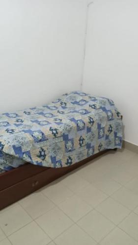a bed with a blue and white quilt on it at Casa Cecilia tiene wifi in General Alvarado