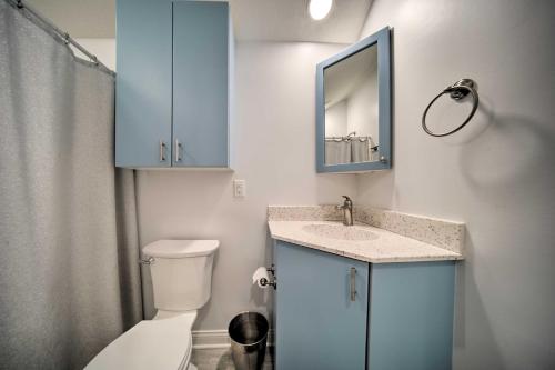 a bathroom with a toilet and a sink and a mirror at Sunny, Modern Waterfront Cottage with Grill in Erie! in Erie