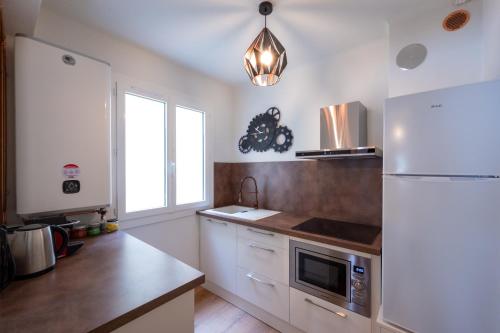 une cuisine avec un réfrigérateur blanc et un évier dans l'établissement Tredici- Appartment, à Cannes