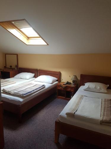 a hotel room with two beds and a skylight at Ada Apartments in Sarajevo