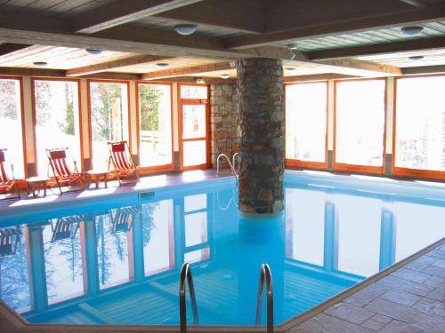 une grande piscine avec des chaises et des fenêtres dans l'établissement Appartement 3 pièces · 2 chambres · Piscine · Parking · Proche pistes - FR-1-181-2625, à La Plagne Tarentaise