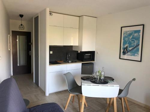 une cuisine avec une table et des chaises dans une pièce dans l'établissement Appartement 2 personnes calme proche de la mer piscine tennis, à Villeneuve-Loubet