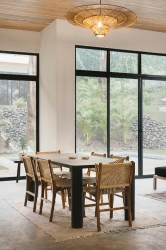 a dining room with a table and chairs and a chandelier at Casa Arcilla NEW LISTING in Nosara