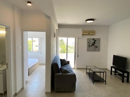 a living room with a couch and a television at 1-bedroom apartment with view in Limassol