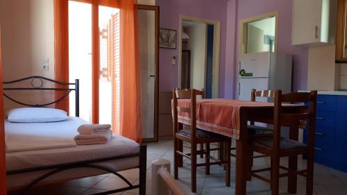 Zimmer mit einem Tisch und Stühlen sowie einer Küche in der Unterkunft Sivota apartments Parthenia in Syvota