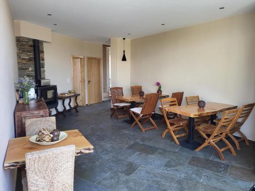 una sala da pranzo con tavoli e sedie in legno di Villa Alva Guest House a Coja