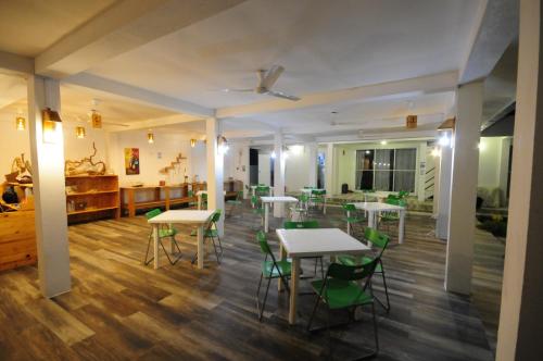 a room with tables and chairs and a dining room at Ocean Voice Beach Resort & Diving in Nolhivaranfaru