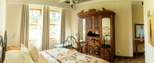 a bedroom with a bed and a large wooden cabinet at Baris Guesthouse in Clarens