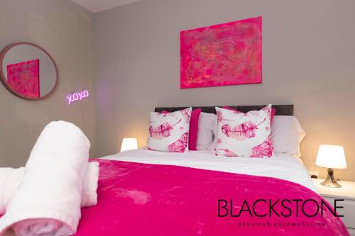 una camera da letto con letto e lenzuola e cuscini rosa di Island House - 3 Bedroom Townhouse by BPNE a Darlington