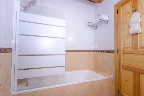 y baño con bañera y ducha. en Hotel Rural Fuente del Val en Prádanos de Ojeda