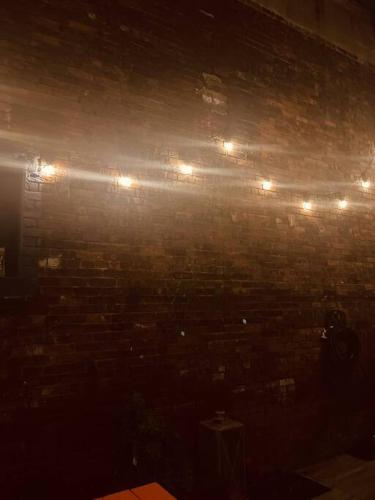 a brick wall with lights on top of it at 1850s historic Row House 7min train to NYC with private backyard in Jersey City
