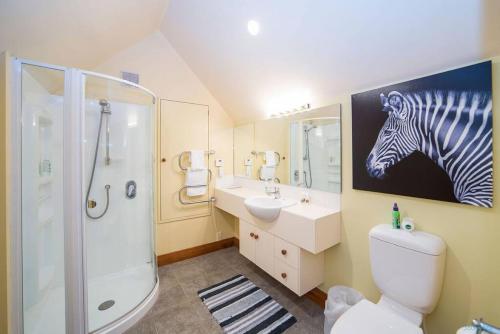een badkamer met een schilderij van een zebra aan de muur bij Nyumbani - Elevated Lake and Mountain Views in Queenstown