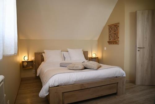 a bedroom with a large bed with two pillows on it at 214 A‘coeur in Hindisheim