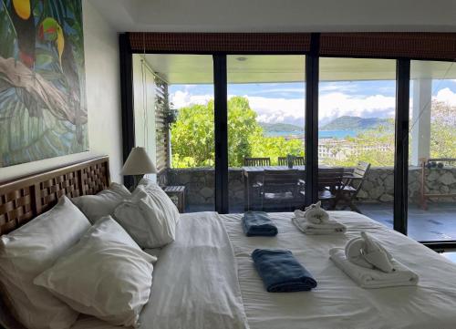 a large white bed with towels and slippers on it at Andaman Hills - panoramic sea view house in Patong in Patong Beach