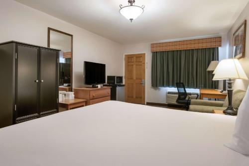 a hotel room with a bed and a living room at SureStay Hotel by Best Western Leesville in Leesville