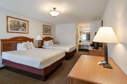 pokój hotelowy z 2 łóżkami i stołem z lampką w obiekcie SureStay Hotel by Best Western Leesville w mieście Leesville
