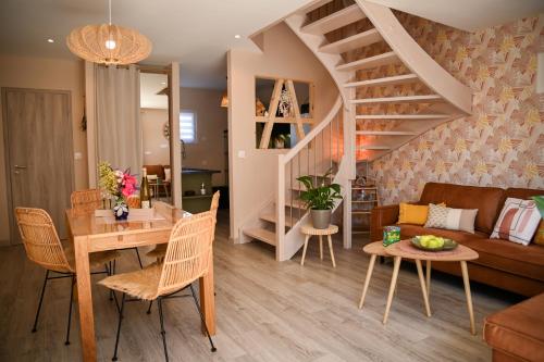 a living room with a table and a couch and a stair at 214 A‘coeur in Hindisheim
