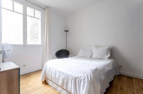 une chambre blanche avec un lit blanc et une fenêtre dans l'établissement Beautiful apartment in center Paris, à Paris