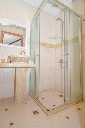 a glass shower in a bathroom with a sink at Guest House Villa Elma in Nevsha
